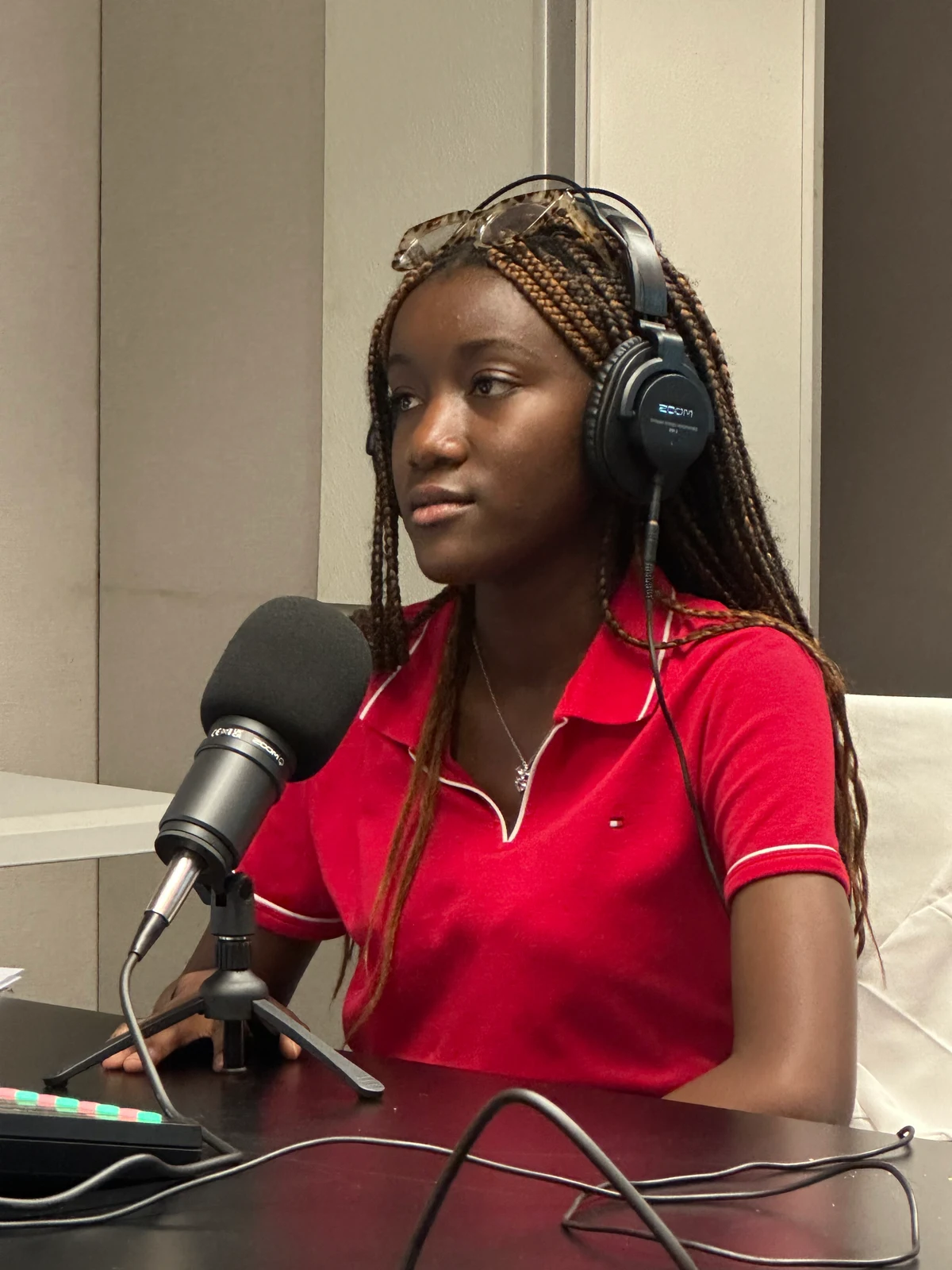 A student in headphones at the microphone during a recording session.